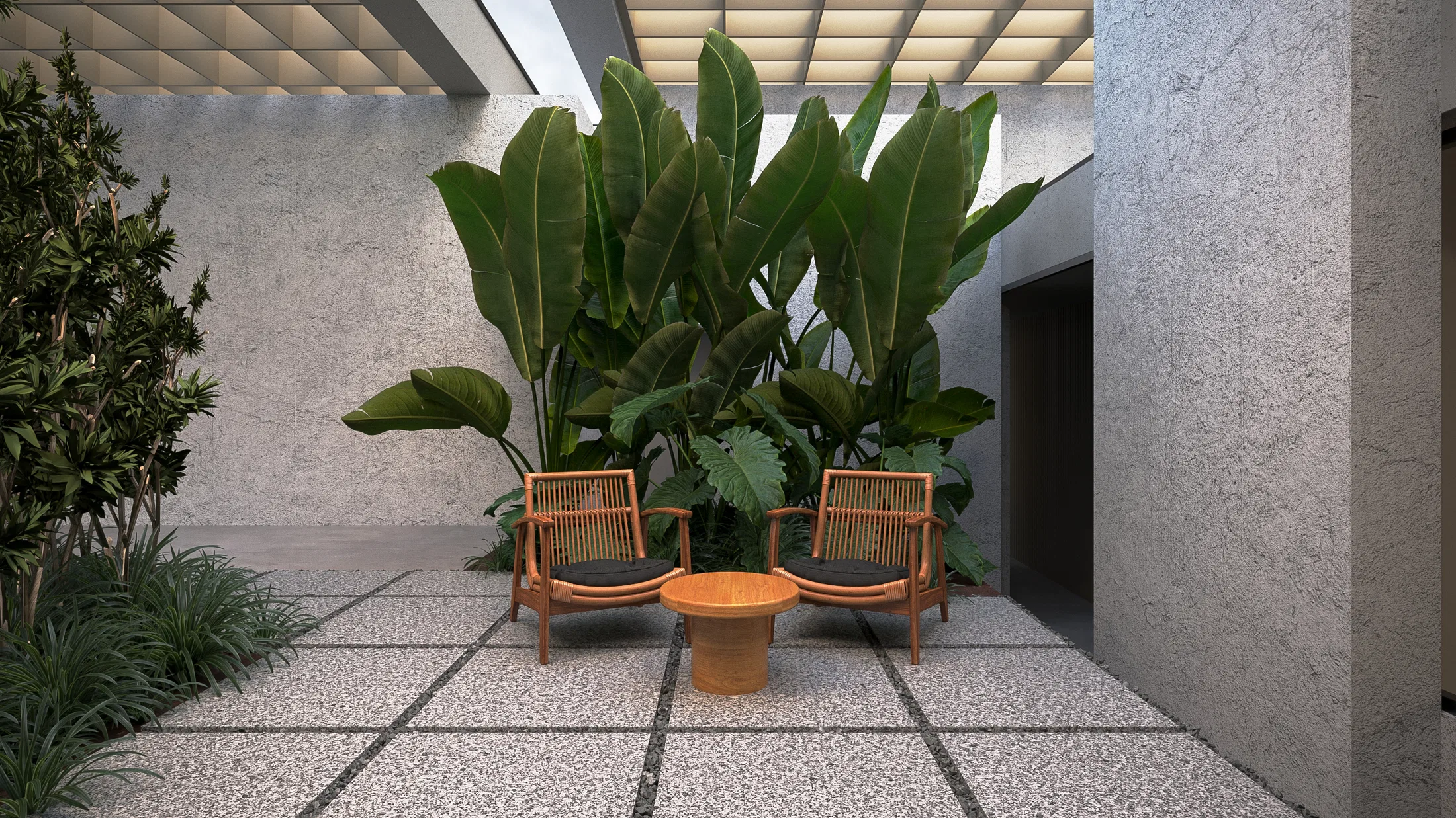 Enclosed courtyard with two wooden armchairs and a round side table before broad tropical foliage, framed by textured walls and terrazzo paving