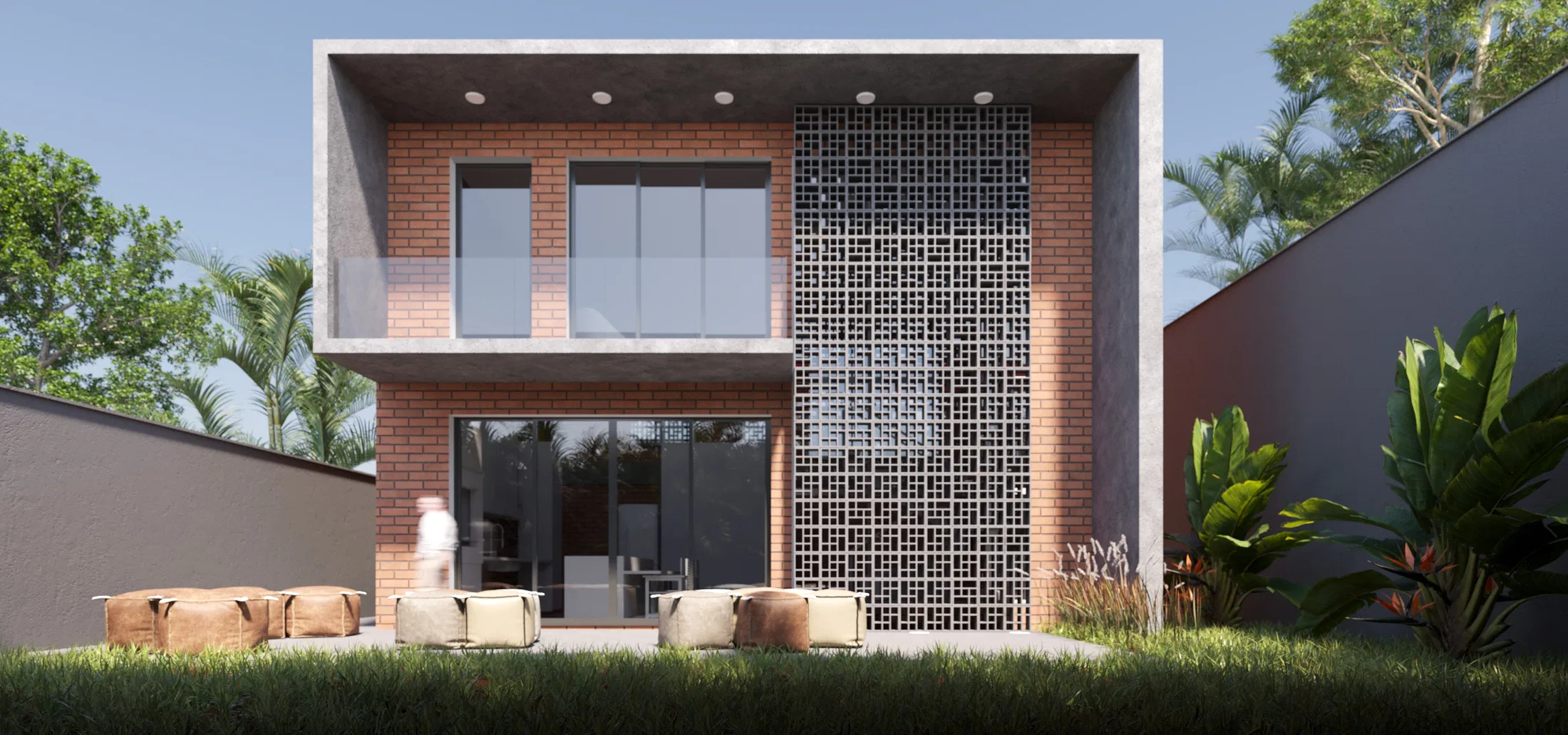 Daytime front view of the two-story brick volume, with the perforated panel, open glass doors and floor cushions in the garden