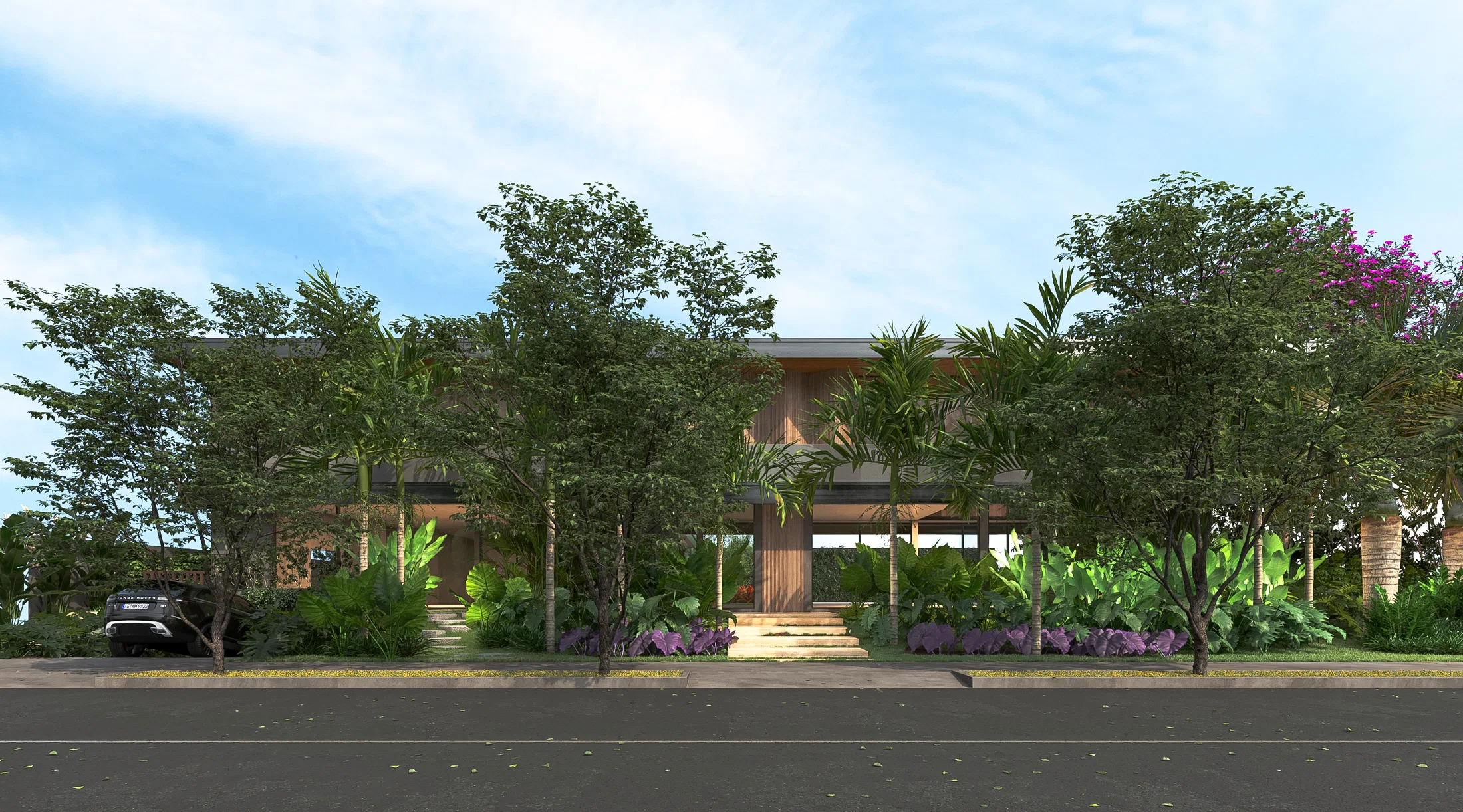 Horizontal residence facade seen from the street, screened by a row of trees, palms and beds of purple-flowering shrubs