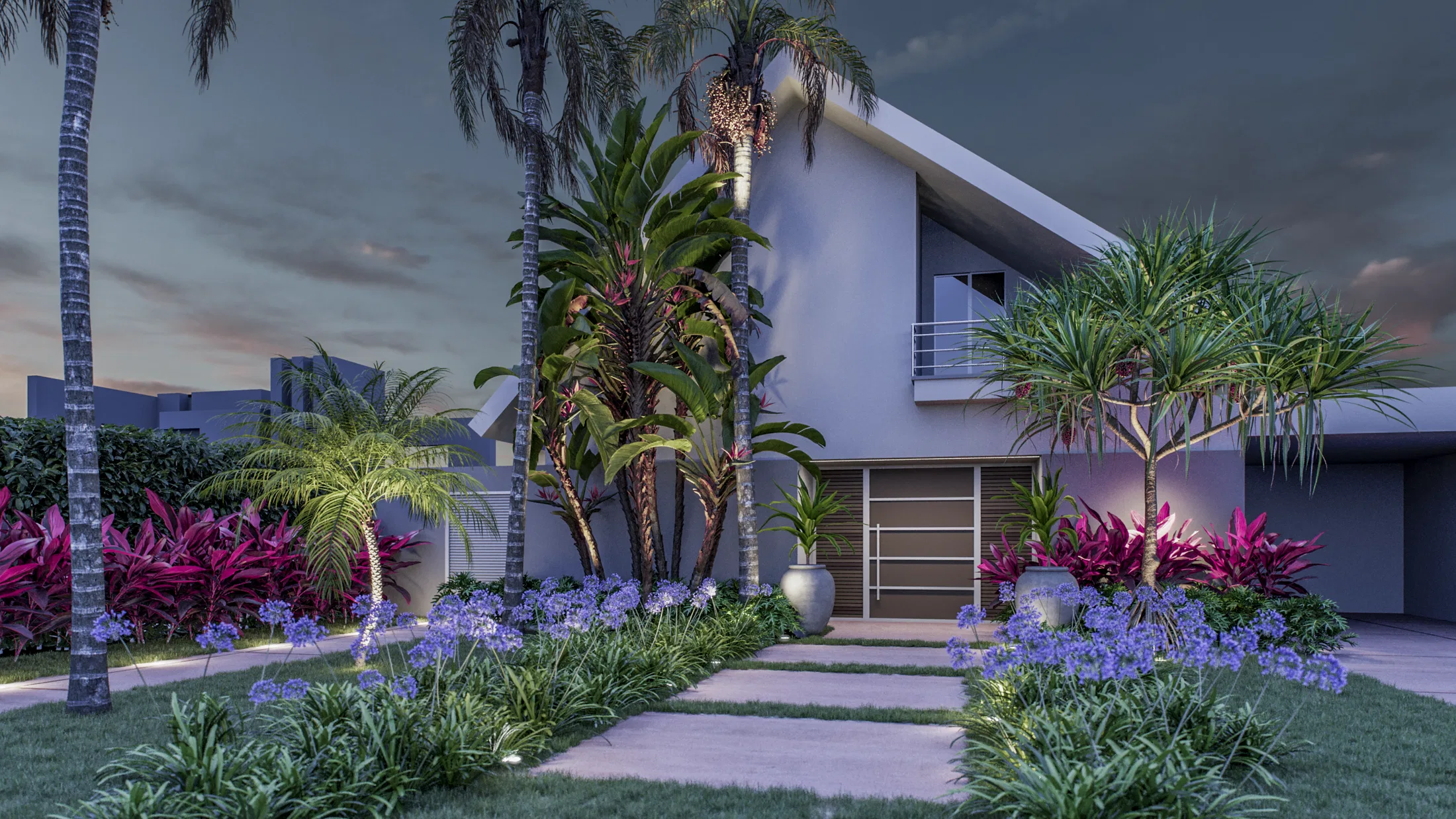 The same house at dusk with blue agapanthus in bloom lining the path, lit palms and beds of colourful foliage by the entrance
